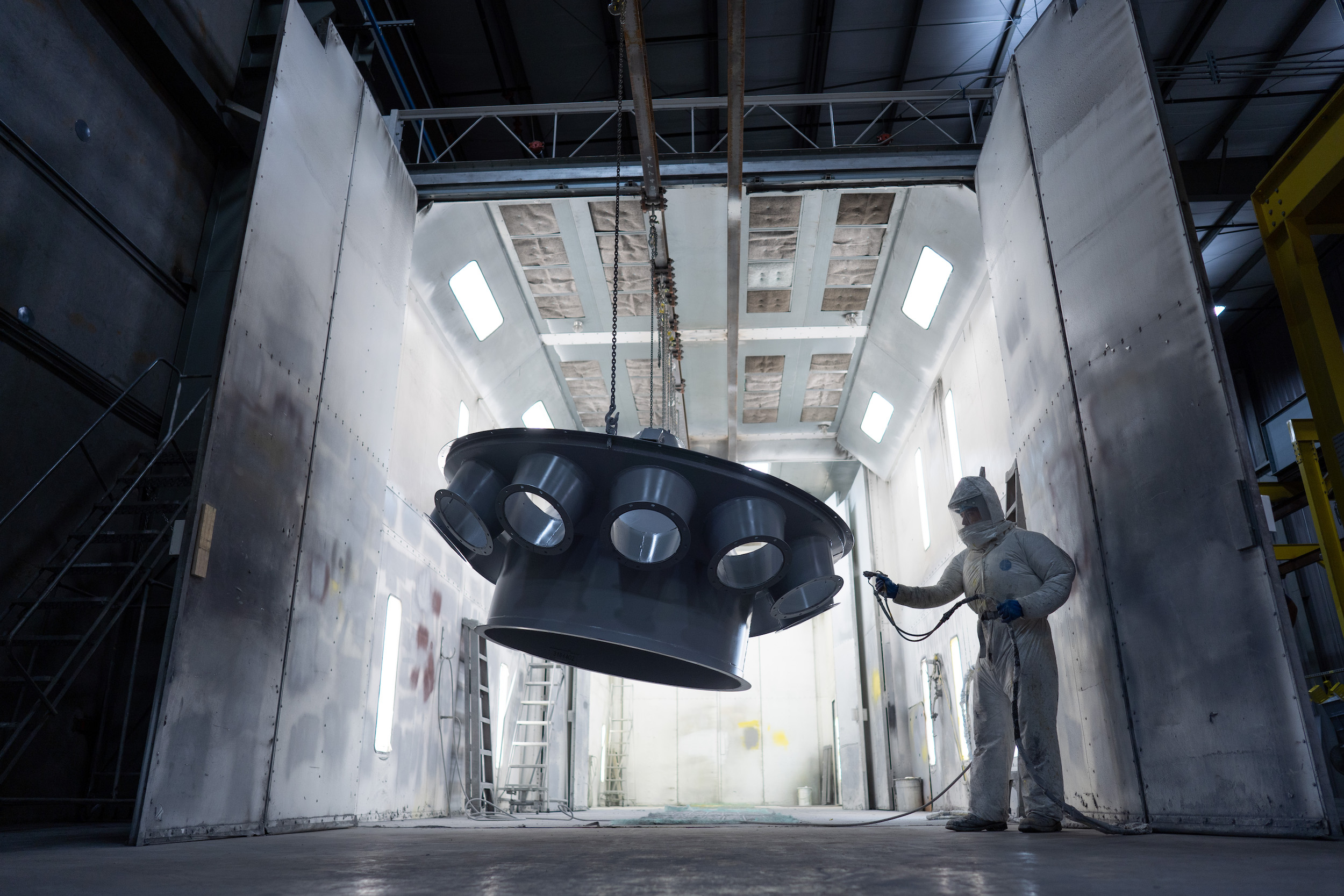 Worker spraying a piece of equipment in a warehouse