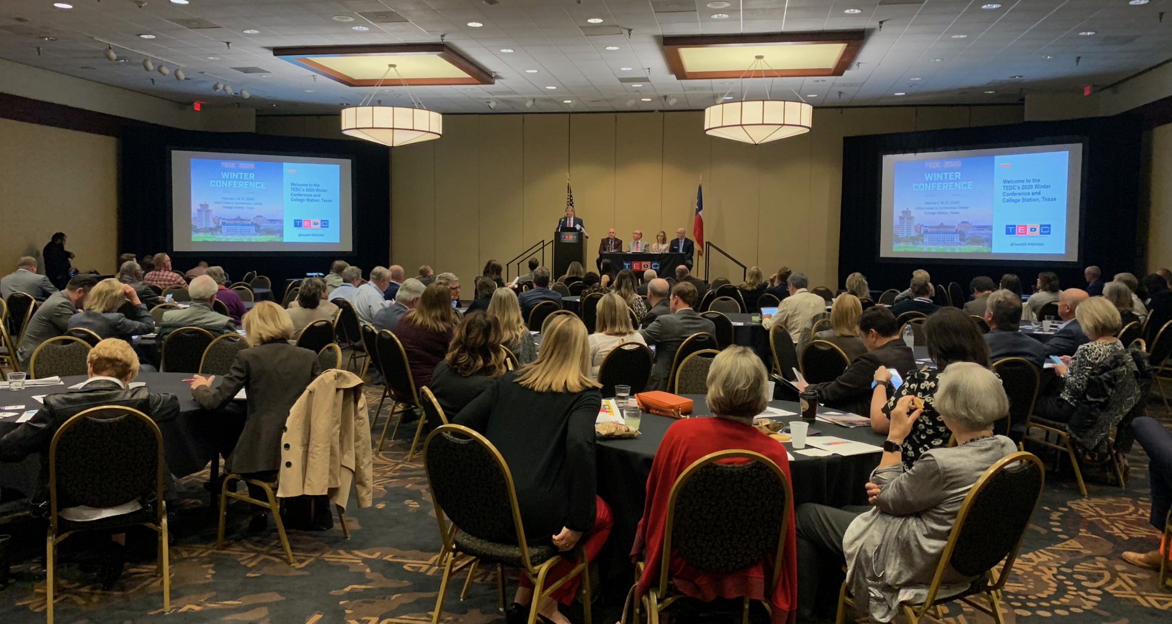 A TEDC conference with attendees surrounding each table