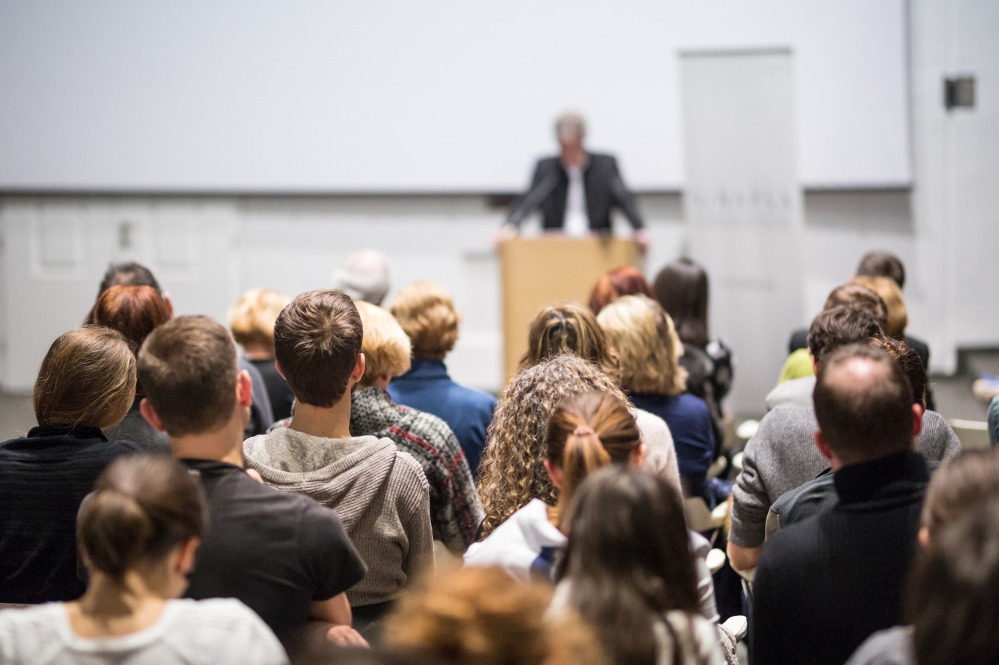 People listening to a man lecture
